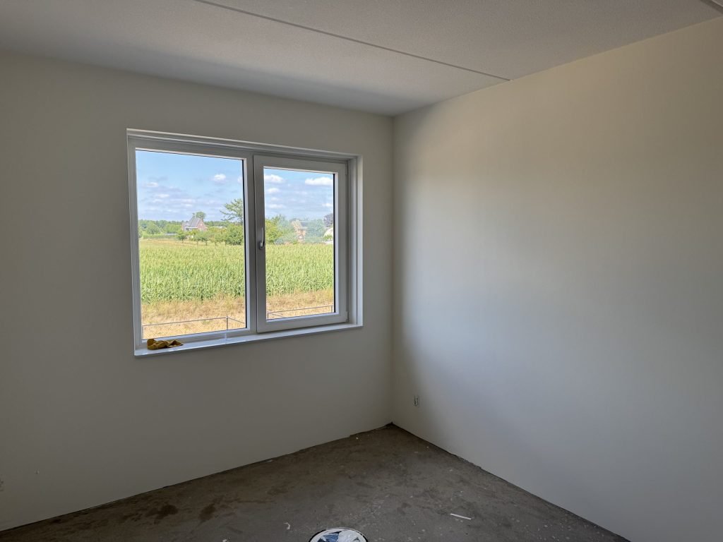 Nieuwbouwkamer met strak afgewerkte wanden na het renovlies behang